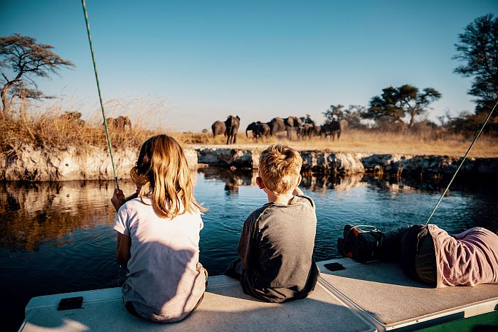 Namibia family safari - enjoying a boat cruise on Kwando river with elephants